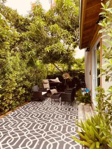a patio with chairs and a table and trees at Bienvenidos a la Pequeña Selva de Legnalife in Homestead