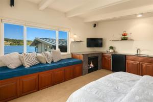 a bedroom with a fireplace and a large window at LakeFront- Private studio on Lake Sammamish in Bellevue