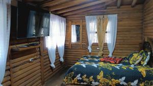 a bedroom with a bed and a flat screen tv at Finca la carolina in Medellín