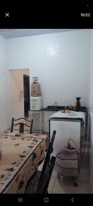 a kitchen with a table and a counter top at Casa Aconchegante Votuporanga in Votuporanga +2 photos