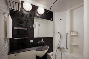 a bathroom with a sink and a toilet and a mirror at Four Points Flex by Sheraton Kyoto Oike in Kyoto