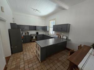 a large kitchen with black cabinets and a black counter top at 38 on Donkin street in Graaff-Reinet