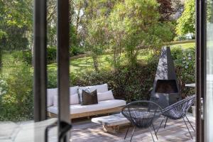 a patio with a white couch and a hammock at Kopanga House - Havelock North Village in Havelock North
