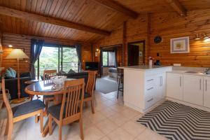 a kitchen and living room with a table and chairs at Lavendula Garden Cottage in Burnt Pine