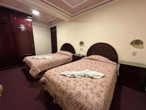 a hotel room with two beds with towels on them at Galax Resort in Oruro
