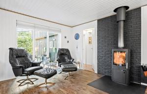 a living room with two chairs and a fireplace at 4 Bedroom Beautiful Home In Skjern in Skjern