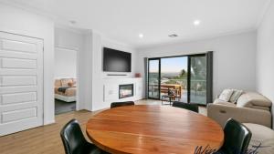 un soggiorno con un tavolo di legno e un divano di Sunrise To Sunset Getaway By Wine Coast Holidays a Port Noarlunga