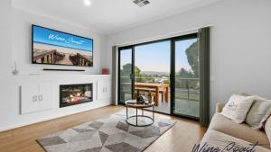 un soggiorno con divano, TV e camino di Sunrise To Sunset Getaway By Wine Coast Holidays a Port Noarlunga
