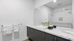 un bagno bianco con lavandino e doccia di Sunrise To Sunset Getaway By Wine Coast Holidays a Port Noarlunga Altre 16 foto