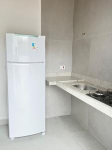 a white refrigerator in a kitchen with a sink at Oasis de Ubatuba in Ubatuba