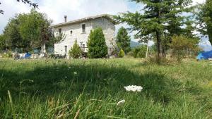 una vieja casa de piedra en un campo de hierba en Casino Tonti Iarussi, en Forlì del Sannio