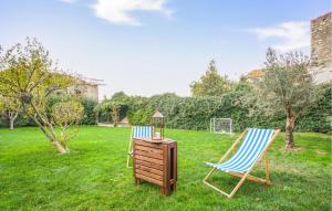 two chairs and a table in a yard at Nice Home In Lusignano D'albenga in Lusignano
