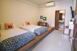 清莱Sleepy House Chiang Rai的卧室里有两张床和一台电视 更多101张照片