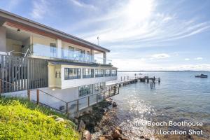 a house on the shore of a body of water at Little Hut 1 Spectacular Water Views NBN and Air Conditioned in Nelson Bay