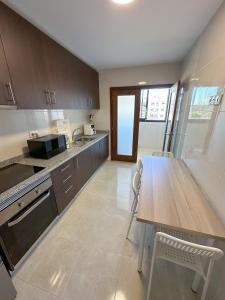 a kitchen with a wooden table and a table and chairs at Espinho in São Félix da Marinha