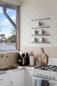 a kitchen with a stove and a sink and a window at Pad Off Pier - 2BR, Wifi in Glenelg +33 photos