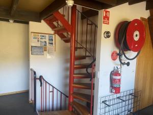un escalier en colimaçon dans un bâtiment équipé d'un extincteur dans l'établissement Moonbah Ski Lodge, à Thredbo