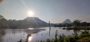 a view of a river with the sun in the background at Sigiriya Little Ceylon Hostel in Sigiriya +20 photos