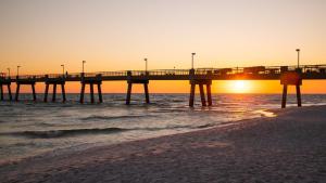 un molo sulla spiaggia con il tramonto di Emerald Coast Gateway a Fort Walton Beach