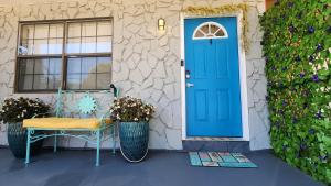 una porta blu su una casa con panchina e fiori di Emerald Coast Gateway a Fort Walton Beach