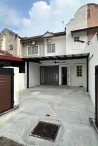 an empty parking lot in front of a white house at Homestay Islam Keluarga Puncak Alam in Bandar Puncak Alam +13 photos