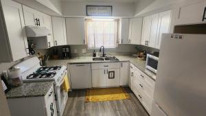 una cucina con armadi bianchi e un piano cottura bianco con forno di Emerald Coast Gateway a Fort Walton Beach