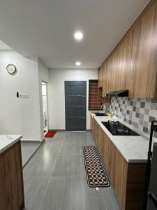 a kitchen with a black door and wooden cabinets at Homestay Islam Keluarga Puncak Alam in Bandar Puncak Alam