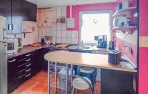 a kitchen with a wooden counter and pink walls at Stunning Home In Penzlin Ot Wustrow in Wustrow