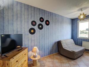 a living room with a television with records on the wall at Gîte rural avec jardin, parking et WiFi - Saint-Romain-en-Jarez - FR-1-496-295 in Saint-Romain-en-Jarez