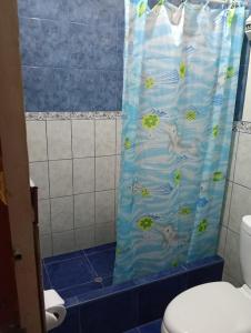 a bathroom with a shower curtain with fish on it at Mama Chelita Hospedaje in Nazca