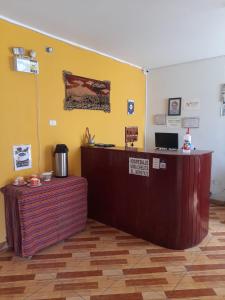 a reception desk in a room with a yellow wall at Mama Chelita Hospedaje in Nazca