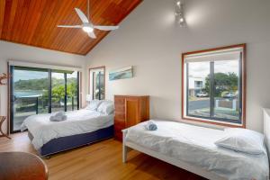 a bedroom with two beds and a ceiling fan at Peninsula in Sawtell +20 photos