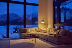 a living room with a couch and a large window at Hakuba Aura Chalet by Jade Villa in Hakuba