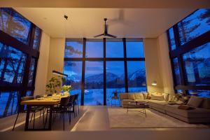 a living room with a table and a large window at Hakuba Aura Chalet by Jade Villa in Hakuba