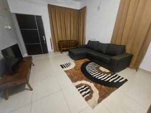 un soggiorno con divano nero e tappeto di alif homestay kulim a Kulim 1 altra foto