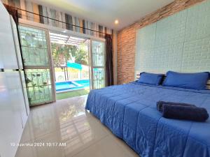 een slaapkamer met een blauw bed en een groot raam bij Plus2 Hua-Hin Private Poolvilla from beach 3km in Hua Hin +63 foto's