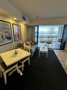 ein Wohnzimmer mit Sofa und Tisch in der Unterkunft Five o clock somewhere in Golden Beach