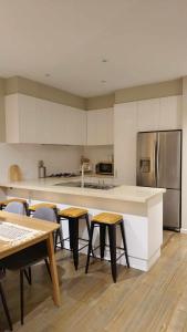 a kitchen with tables and a counter with a refrigerator at Yarra Valley Retreat - Kids, Wine, Outdoors in Healesville +19 photos