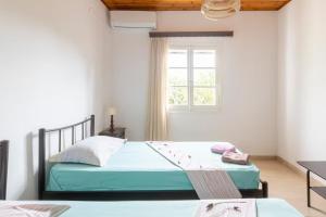 a bedroom with two beds and a window at Private Villa Dula with Ocean View in Corfu Town