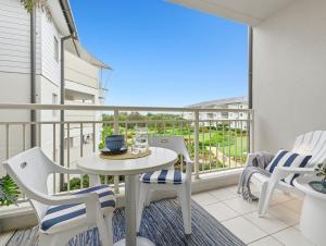 un balcon avec une table et des chaises et une vue dans l'établissement The Pool Resort Kingscliff - Studio with Garden View (5203) - Holiday Management Co., à Kingscliff 1 autre photo