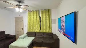 a living room with a couch and a ceiling fan at Casa familiar com 2 quartos 2 banheiros perto de Sao Bernardo do Campo in São Bernardo do Campo