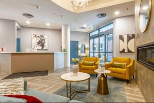 a living room with yellow chairs and a table at Ideal Central Village Location! in Whistler