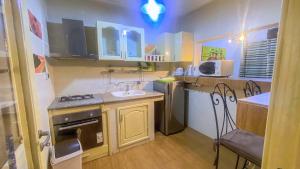 a small kitchen with a sink and a stove at Résidence Nopeli in Cotonou