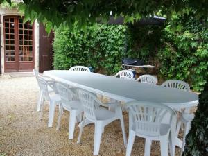 a white table with white chairs and an umbrella at Maison campagnarde avec piscine, animaux acceptés, Wi-Fi, parking, cheminée - FR-1-616-424 in Thenon +2 photos