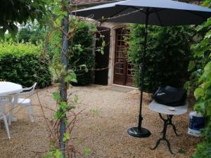 a black umbrella and a table and a table and a chair at Maison campagnarde avec piscine, animaux acceptés, Wi-Fi, parking, cheminée - FR-1-616-424 in Thenon