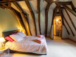 a bed in a room with wooden beams at Maison campagnarde avec piscine, animaux acceptés, Wi-Fi, parking, cheminée - FR-1-616-424 in Thenon