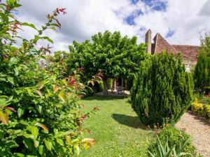 a garden in front of a house with trees and bushes at Maison campagnarde avec piscine, animaux acceptés, Wi-Fi, parking, cheminée - FR-1-616-424 in Thenon