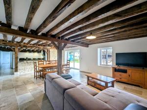 un salon avec un canapé, une télévision et une table dans l'établissement Maison familiale rénovée dans village médiéval - FR-1-591-712, à Levroux