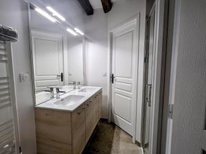 une salle de bain blanche avec un lavabo et un miroir dans l'établissement Maison familiale rénovée dans village médiéval - FR-1-591-712, à Levroux 16 autres photos