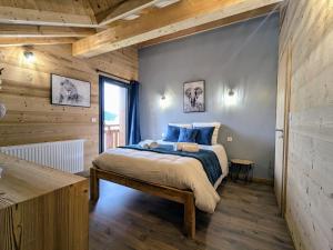 a bedroom with a bed and a wooden wall at Chalet grand confort avec sauna et balnéo - Proche stations de ski - FR-1-589-762 in Xonrupt-Longemer